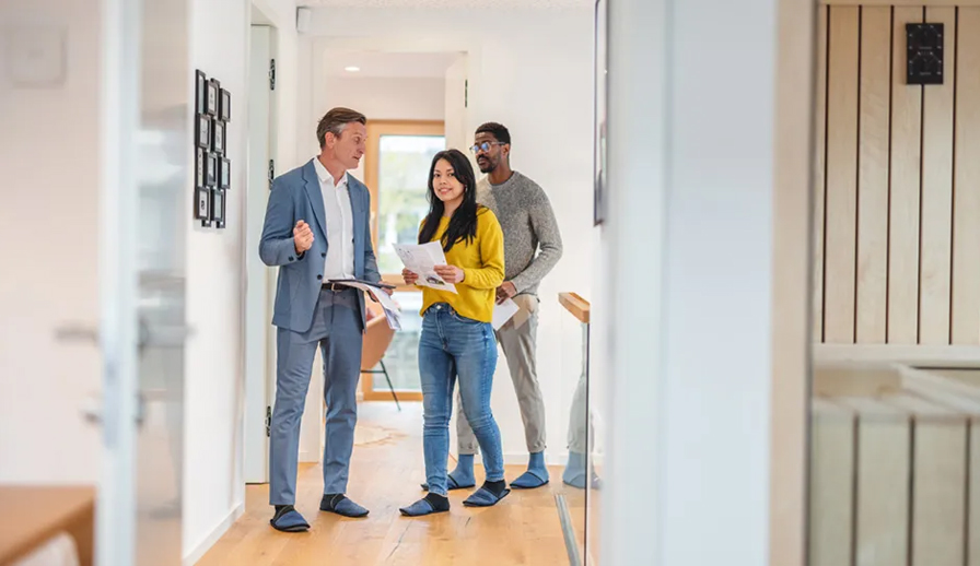 Real estate agent showing home to couple. 