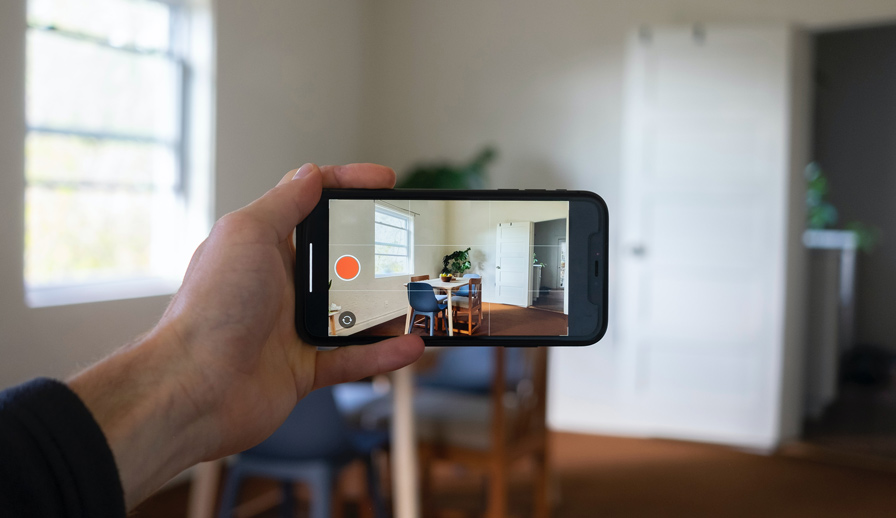 Phone in front of room through camera viewfinder. 