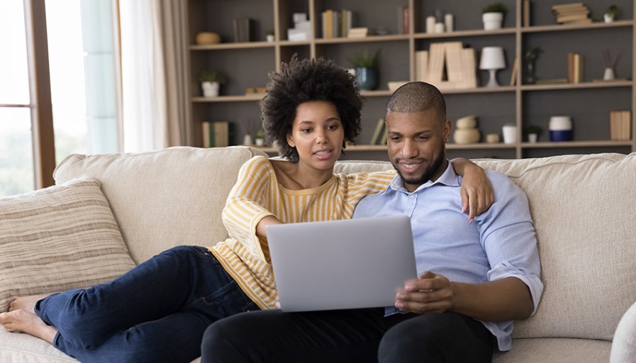 Couple looking at a laptop together. 