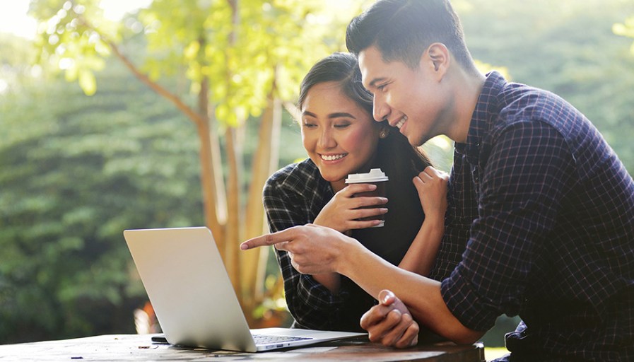 Couple looking at a laptop together.