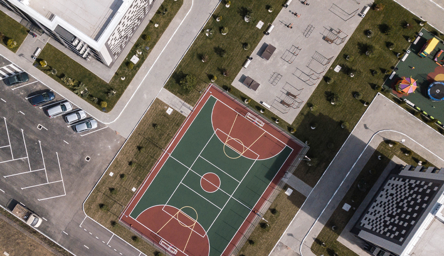 Aerial shot of sports court and apartment buildings. 