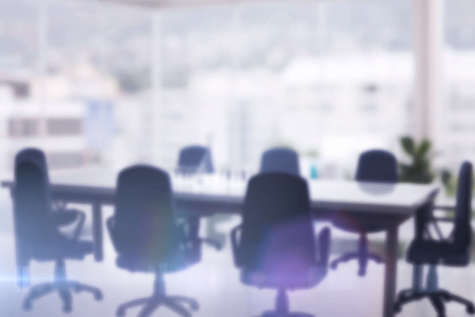 The banner shows a modern conference room with sleek office chairs surrounds a polished table, set against a backdrop of large windows overlooking the city. The blurred effect adds a sense of professionalism and focus.